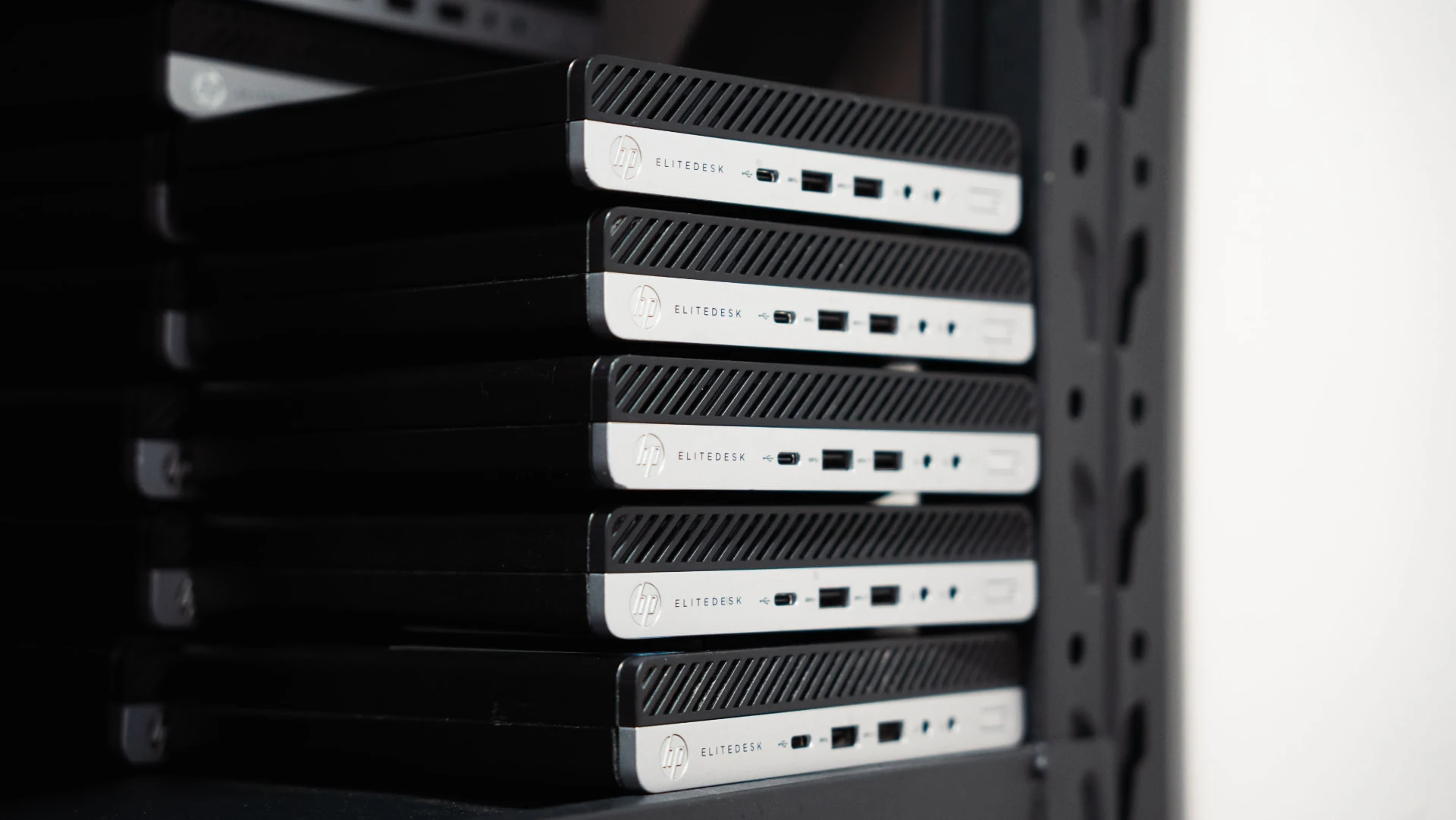 Multiple HP EliteDesk computers stacked on warehouse shelving at The Recycle Project